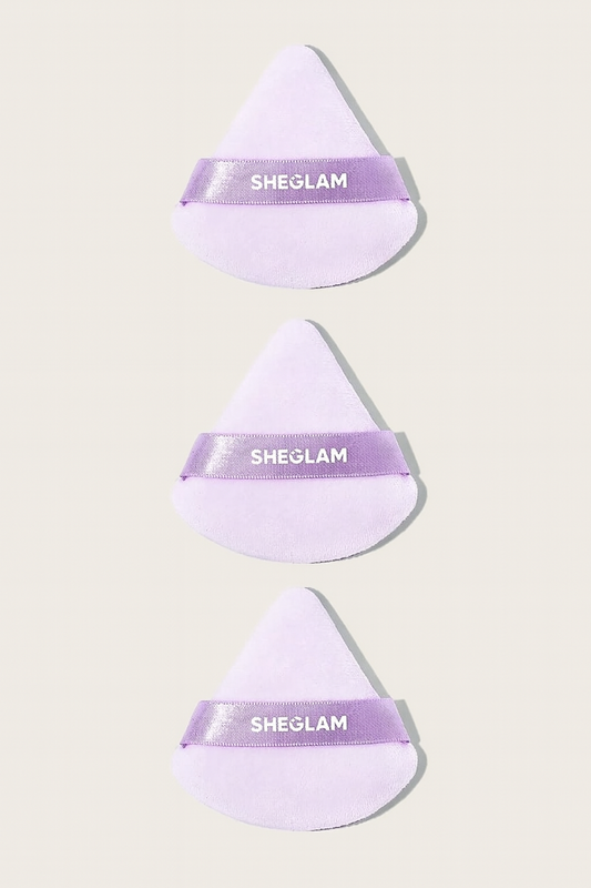 Three purple makeup sponges with 'SHEGLAM' branding on a light beige background
