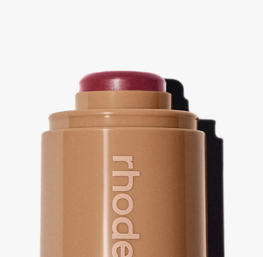 Cosmetic stick with 'rhode' branding on a white background